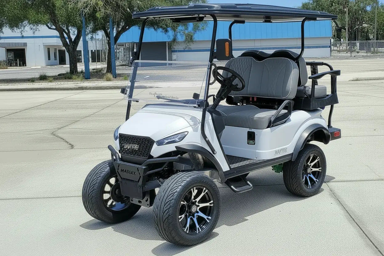 Navitas chassis with a frost white metallic body grey seats driver front view in front parking lot