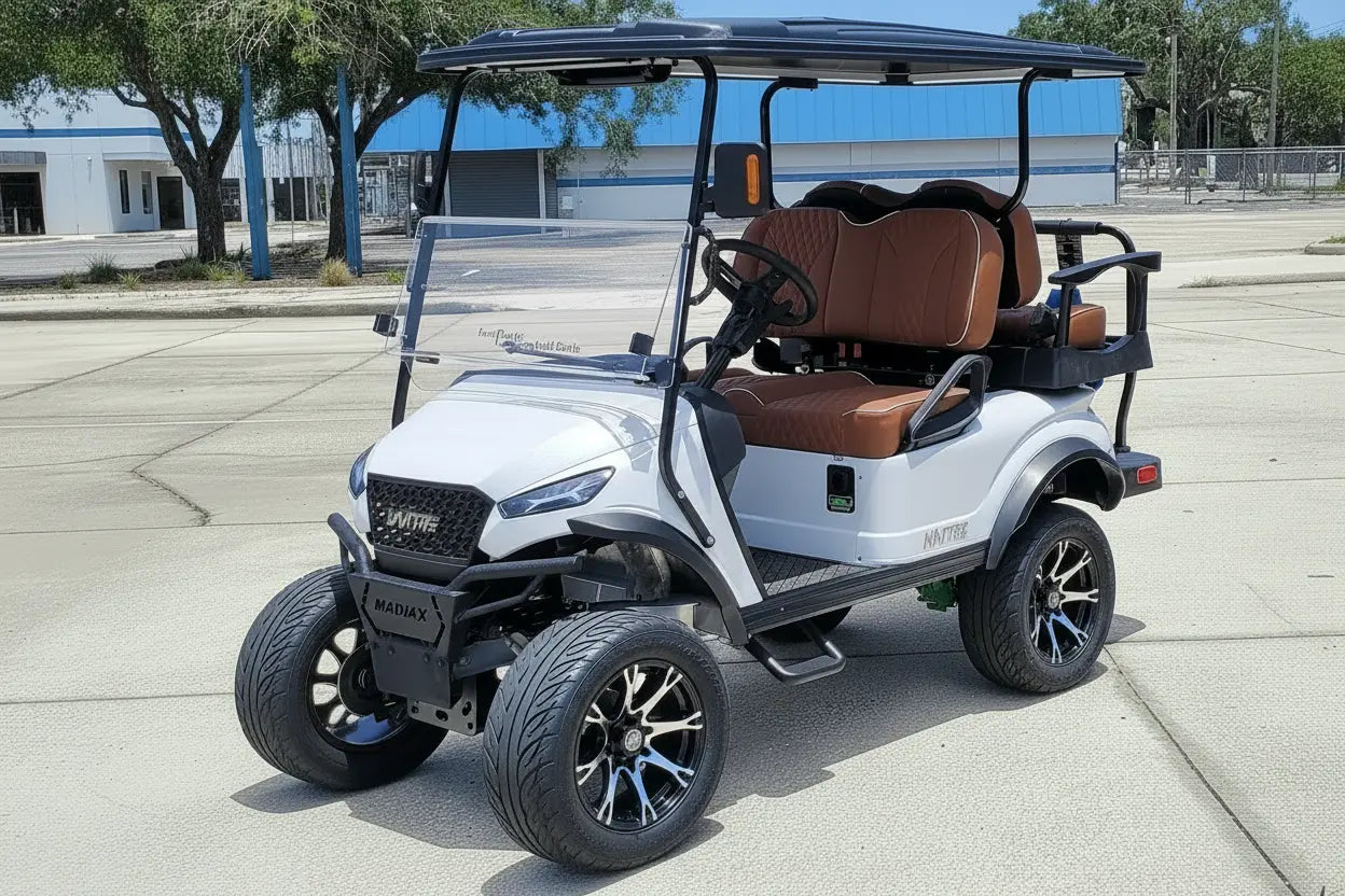Navitas chassis with a frost white metallic body rust brown seats driver front view in front parking lot