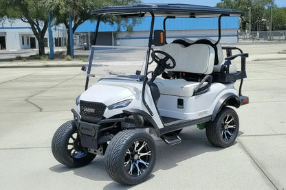 Navitas chassis with a frost white metallic body white seats driver front view in front parking lot